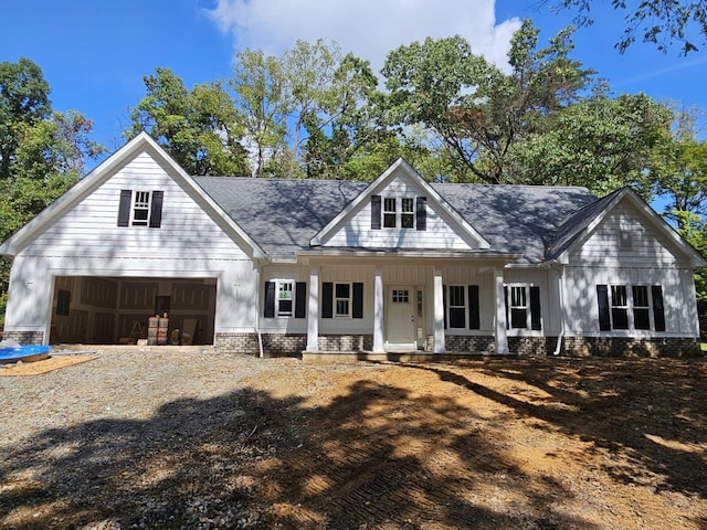 modern farmhouse style home featuring covered porch and a garage