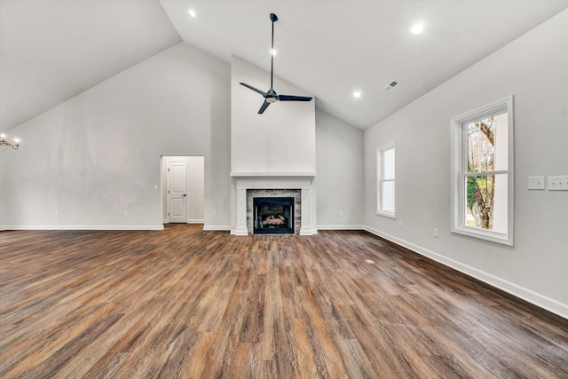 unfurnished living room featuring hardwood / wood-style flooring, ceiling fan, and high vaulted ceiling