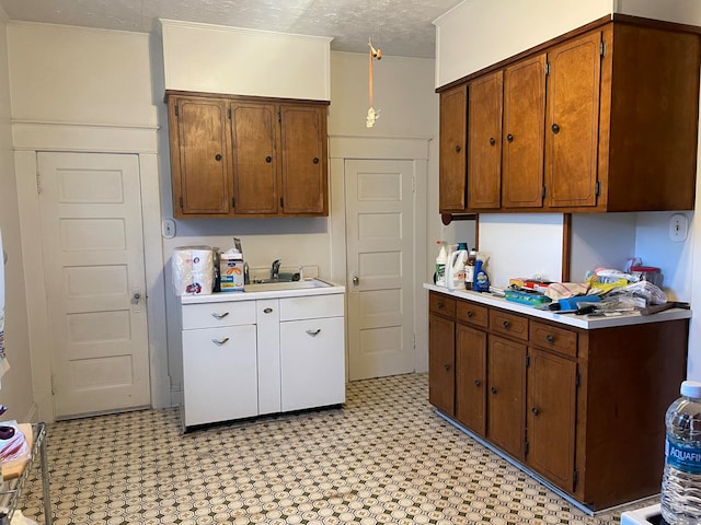 kitchen with crown molding, a textured ceiling, and sink