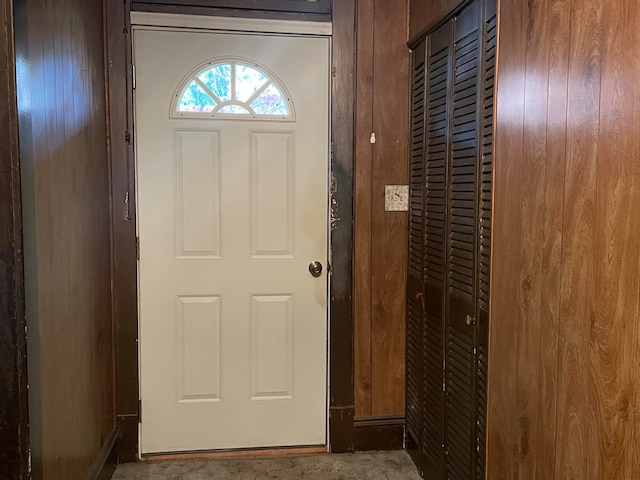 doorway to outside featuring wooden walls