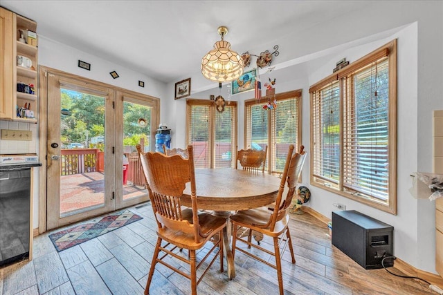 dining area with french doors, baseboards, an inviting chandelier, and wood finished floors