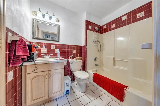 bathroom featuring washtub / shower combination, toilet, vanity, tile patterned floors, and tile walls