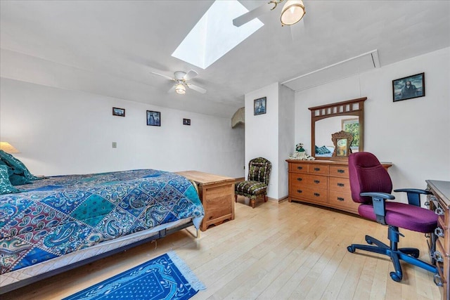 bedroom with a skylight, wood-type flooring, attic access, and ceiling fan