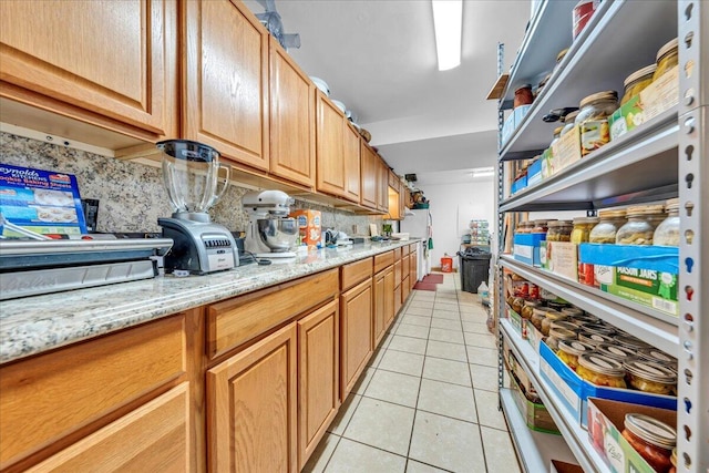 kitchen featuring light tile patterned flooring, tasteful backsplash, and light stone countertops