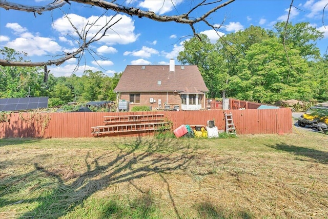 back of house featuring a yard, a chimney, and fence