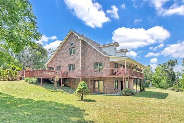 rear view of property with a yard, brick siding, and a deck