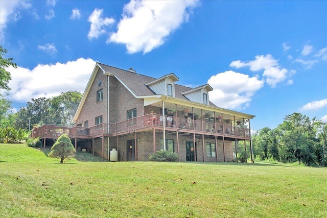 back of house featuring brick siding, a wooden deck, and a yard