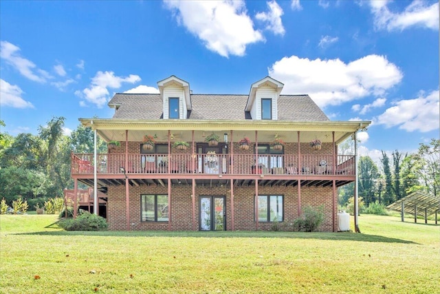 back of property with a lawn, brick siding, and roof with shingles