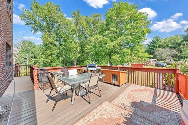 wooden deck with outdoor dining space and a grill