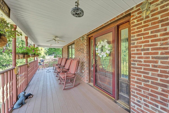 wooden terrace with covered porch and a ceiling fan