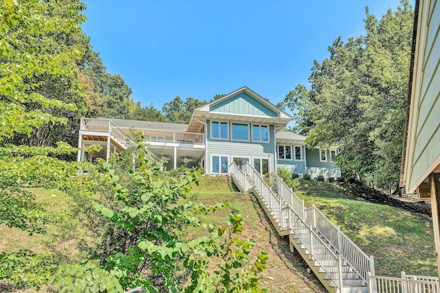 back of property with stairway and board and batten siding