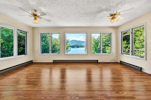 interior space featuring ceiling fan, hardwood / wood-style flooring, a textured ceiling, and a healthy amount of sunlight