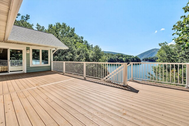 wooden deck with a water and mountain view