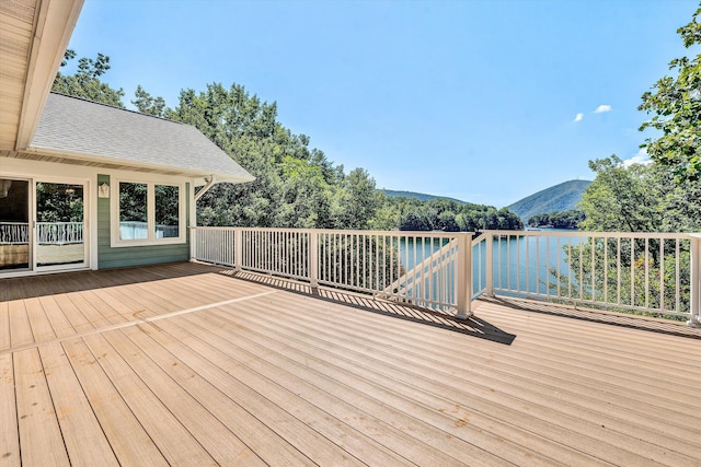 wooden deck with a water and mountain view