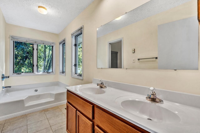 bathroom featuring vanity, a bath, tile patterned floors, and a textured ceiling