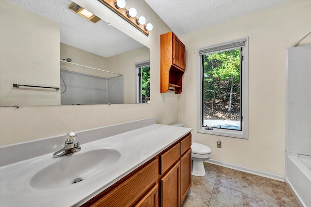 bathroom featuring baseboards, toilet, tile patterned floors, a textured ceiling, and vanity