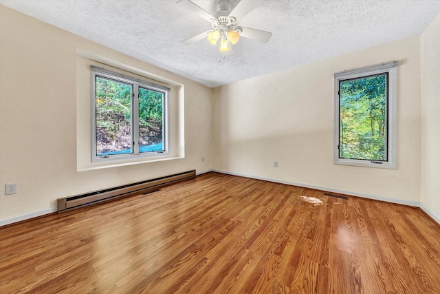 unfurnished room with a textured ceiling, baseboard heating, ceiling fan, and light hardwood / wood-style floors