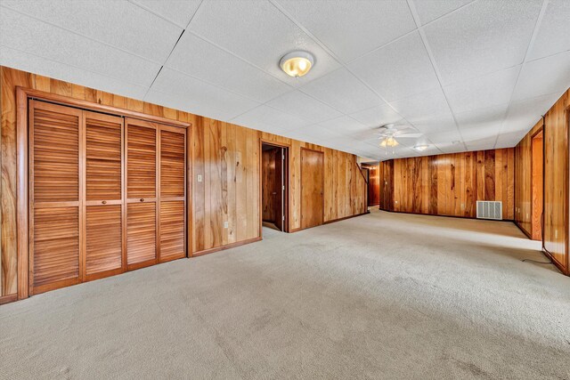 interior space featuring a paneled ceiling, ceiling fan, and light carpet