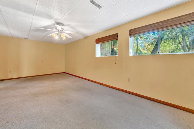 empty room with carpet floors, baseboards, visible vents, and a ceiling fan