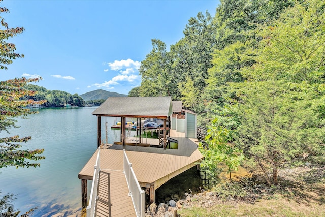 view of dock featuring boat lift and a water and mountain view