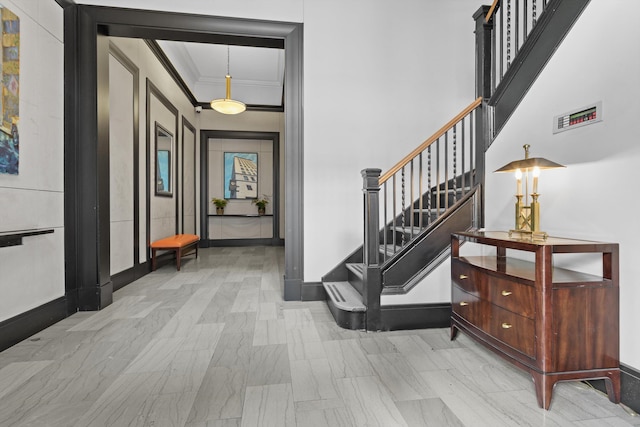 entrance foyer featuring ornamental molding and a towering ceiling