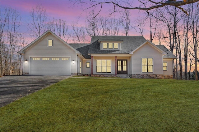 view of front of property featuring a garage and a lawn