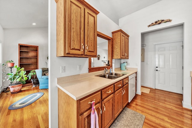 kitchen with lofted ceiling, sink, light hardwood / wood-style flooring, and white dishwasher