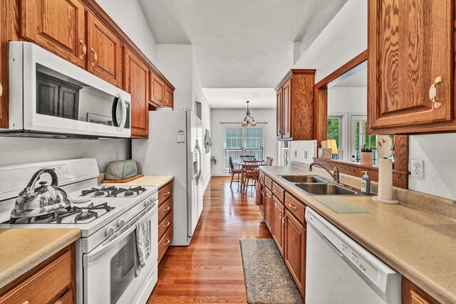 kitchen with sink, light hardwood / wood-style floors, and white appliances