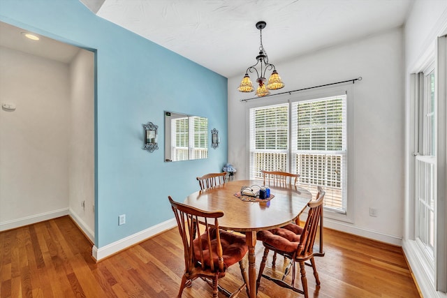 dining room with light wood-type flooring and a chandelier