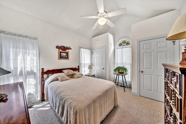 bedroom with ceiling fan, lofted ceiling, and light carpet