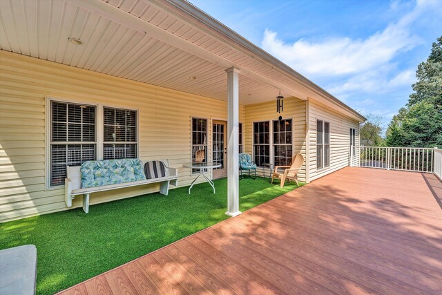 wooden terrace featuring a lawn