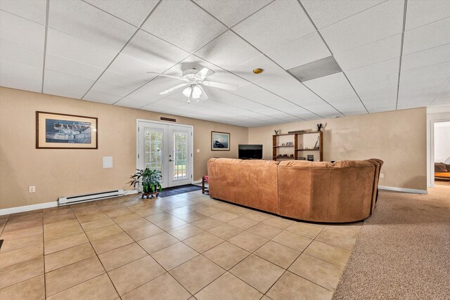 living room with light tile patterned floors, a drop ceiling, ceiling fan, french doors, and a baseboard radiator