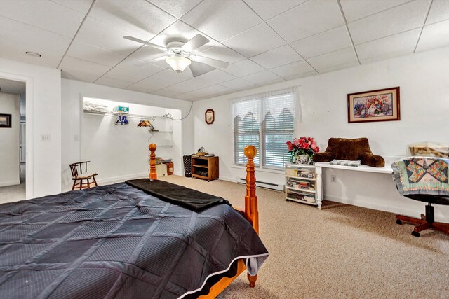 bedroom with a baseboard radiator, ceiling fan, a drop ceiling, and carpet floors