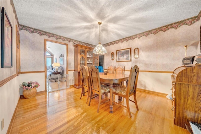 dining room with a textured ceiling and light hardwood / wood-style flooring