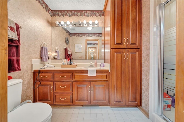 bathroom featuring vanity, an enclosed shower, a textured ceiling, and toilet