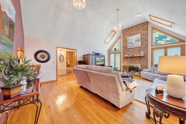 living room with a healthy amount of sunlight, a skylight, light hardwood / wood-style floors, and a brick fireplace