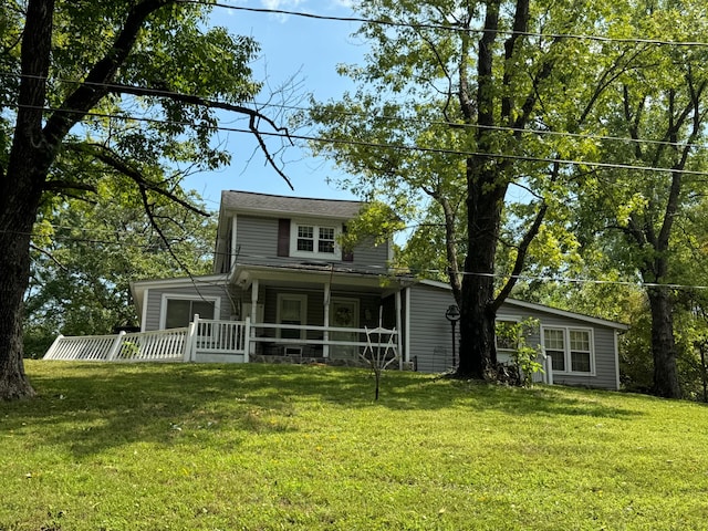 rear view of property featuring covered porch and a lawn