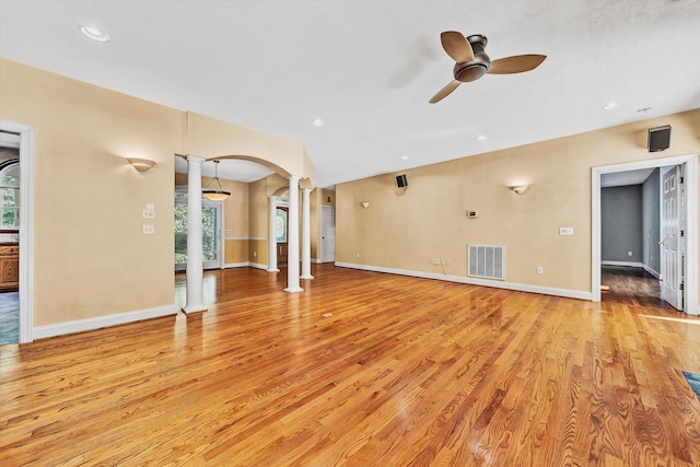 unfurnished living room featuring decorative columns, ceiling fan, and light hardwood / wood-style flooring