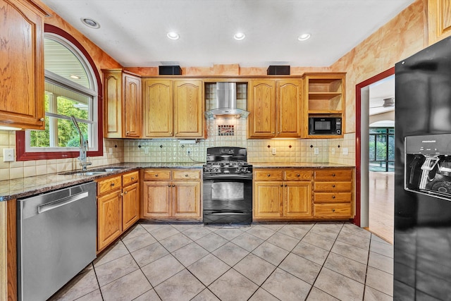 kitchen featuring dark stone counters, wall chimney exhaust hood, light tile patterned flooring, and black appliances