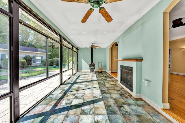 unfurnished sunroom featuring ceiling fan