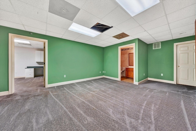 unfurnished room with a paneled ceiling and carpet