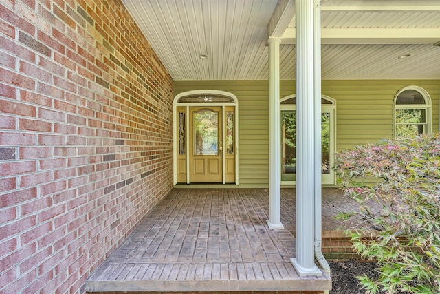 view of exterior entry featuring covered porch