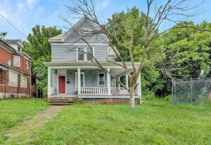 view of front of home with covered porch and a front lawn