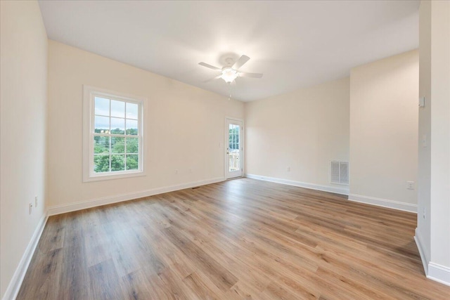 empty room with light wood-type flooring, baseboards, visible vents, and a ceiling fan