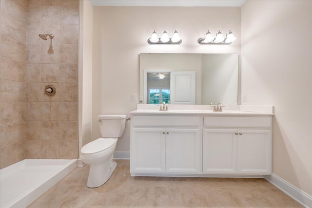 bathroom with toilet, double vanity, tiled shower, and tile patterned floors