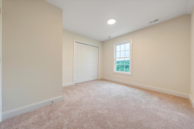 unfurnished bedroom featuring carpet floors, a closet, visible vents, and baseboards