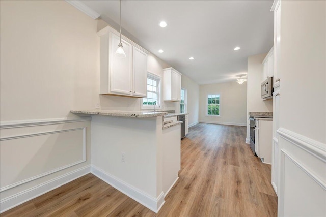 kitchen featuring recessed lighting, light wood-style flooring, appliances with stainless steel finishes, white cabinetry, and a sink