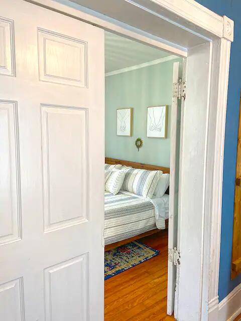 bedroom featuring crown molding and hardwood / wood-style flooring