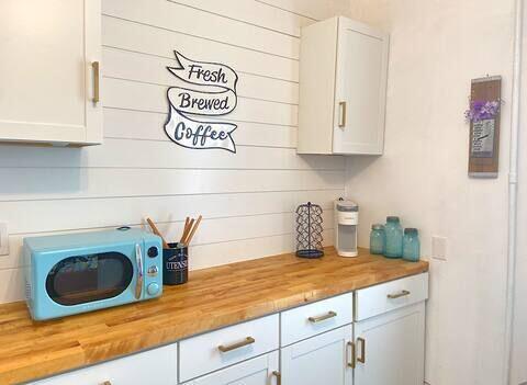 bar with white cabinets and butcher block counters