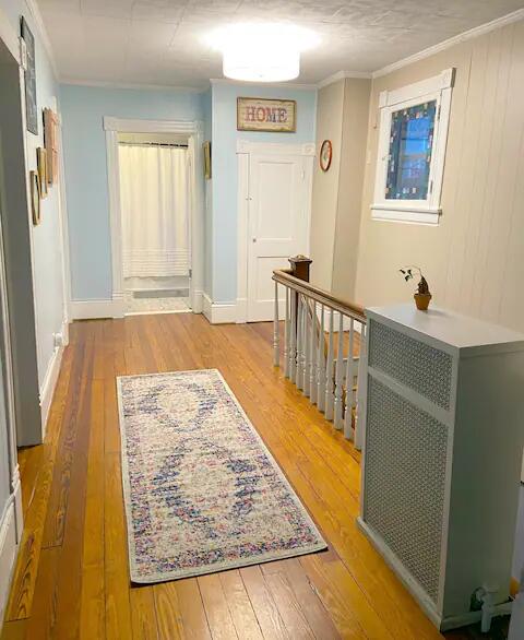 hall featuring crown molding and light hardwood / wood-style floors